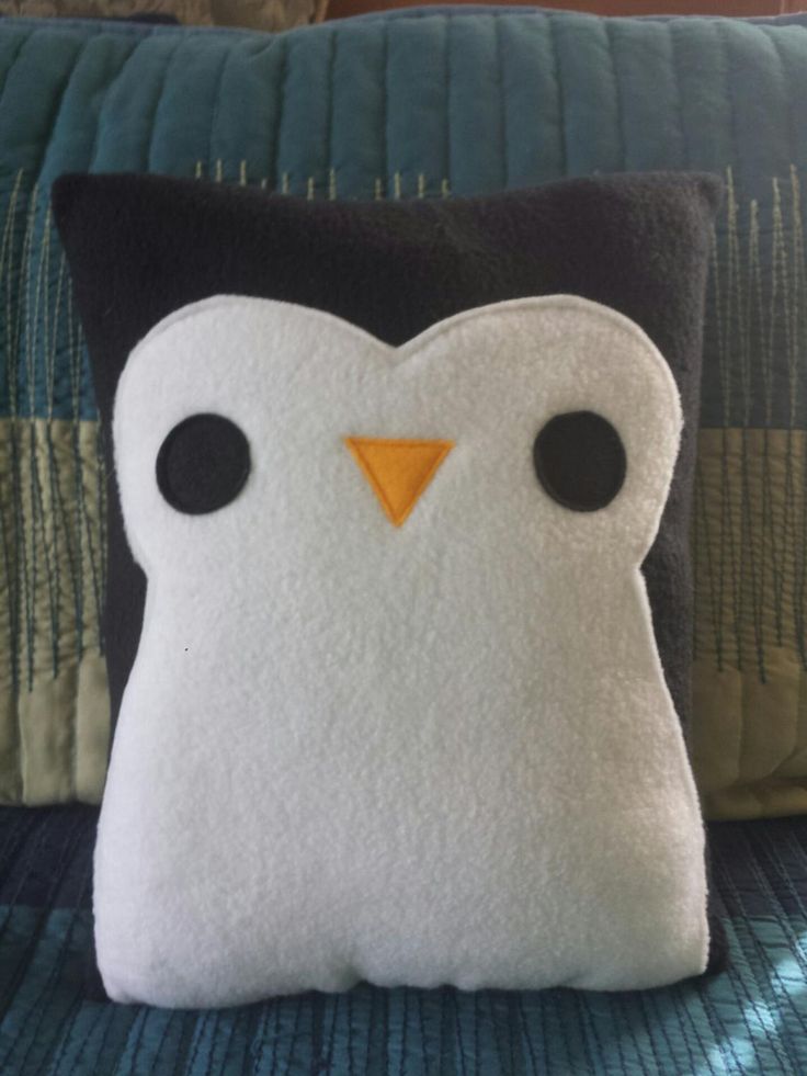 a penguin pillow sitting on top of a bed