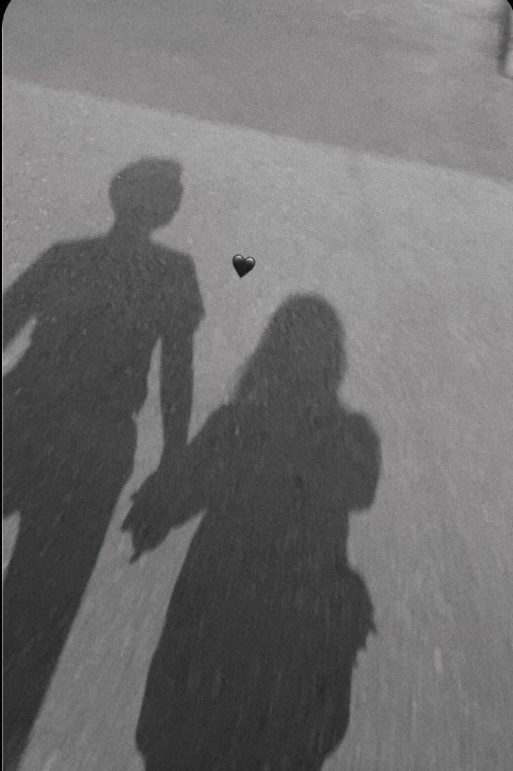 the shadow of two people standing next to each other