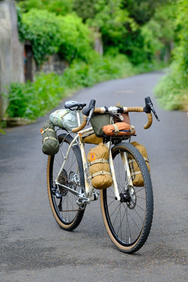 an old bicycle is parked on the side of the road in front of some trees