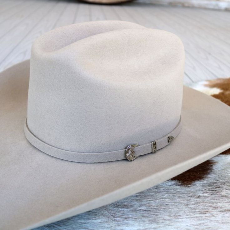 Ariat Double S Wool 3X Silverbelly Cowboy Hat p> Ariat 3X Wool Cowboy Hat  Silver Belly  Self Band With 3 Piece Buckle Set  Genuine Leather Sweatband  Individually Boxed  Crown: 4-1/4"  Brim: 4-1/4"   You will definitely look in style with this wool Ariat hat by M & F Western Products. The quality of this hat will show and it will be your favorite to wear. It features a self-band with 3 piece buckle set and genuine leather sweatband. Treat yourself to this stunning hat. Ariat Cowboy Hats, Casual One-size Felt Hat For Rodeo, Western-style Felt Hat With Curved Brim For Riding, Ariat Hats, Grey Felt Cowboy Hat, White Flat-brim Felt Hat For Ranch, Hat Sizes, 3 Piece, Cowboy Hats