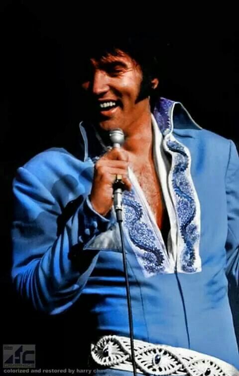 elvis presley singing into a microphone on stage