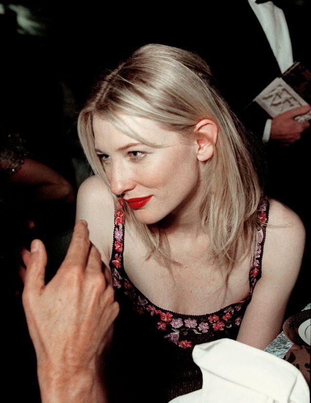 a woman with red lipstick sitting next to an older man