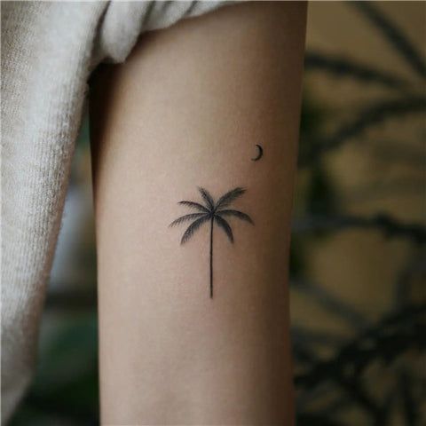 a small palm tree tattoo on the arm