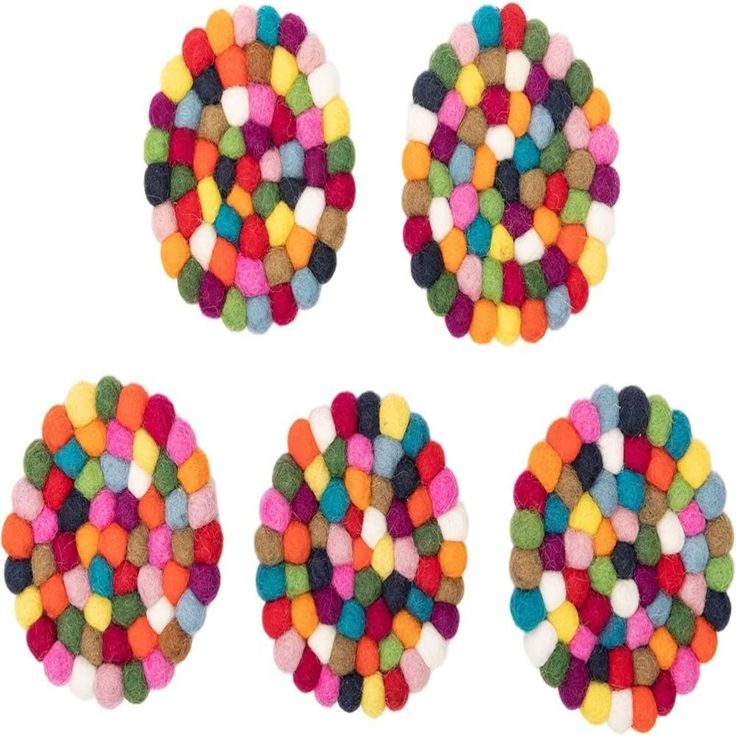 four pieces of multicolored pom poms on top of each other in different colors