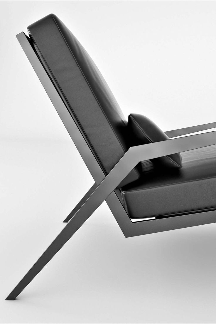 a black and white photo of a modern lounge chair with armrests that are bent to the side