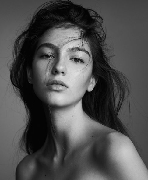 black and white photograph of a naked woman with long hair, looking off to the side