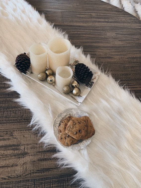 a tray with cookies and candles on a fur rug