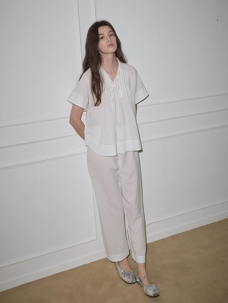 This pajama set features a relaxed fit for comfortable wear experience and collar design to add appeal to the item.- Availalbe in colors: Brown and white- Ribbon at the chest as a refined touch- Made from a soft fabric blend of cotton and tencel Elegant Cotton Relaxed Fit Sleepwear, White Cotton Sets For Workwear, White V-neck Pajama Party Sets, White Relaxed Fit Sets For Pajama Party, White Feminine Sleepwear For Relaxation, Spring White Relaxed Fit Sleepwear, Spring White Sleepwear With Relaxed Fit, Elegant Relaxed Fit Sleepwear For Loungewear, White Feminine Sleepwear With Relaxed Fit