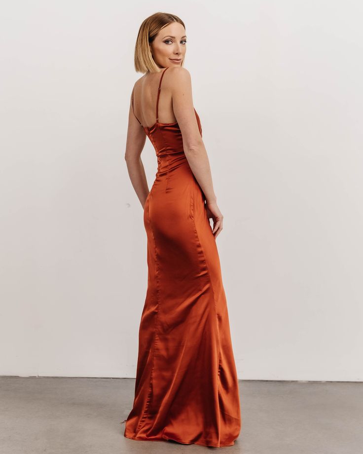 a woman in an orange dress looking back