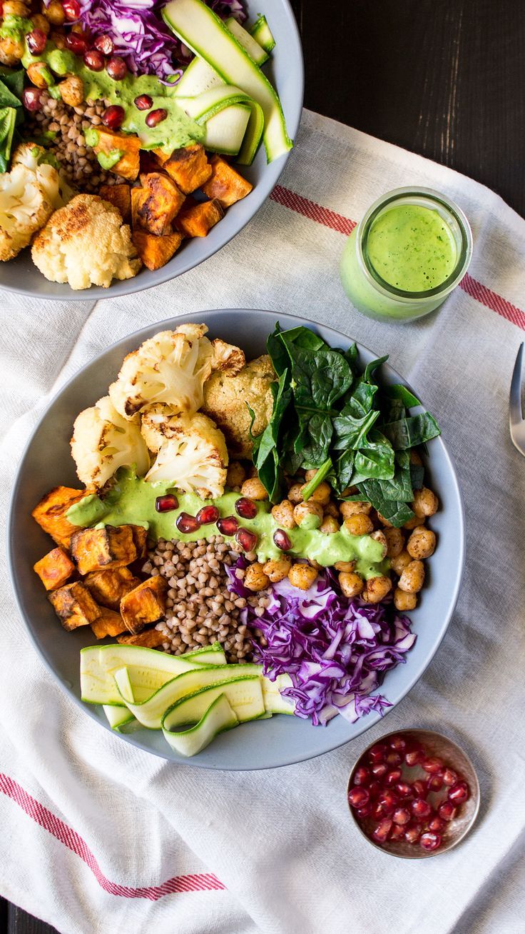 a white plate topped with different types of food next to a bowl of vegetables and dressing