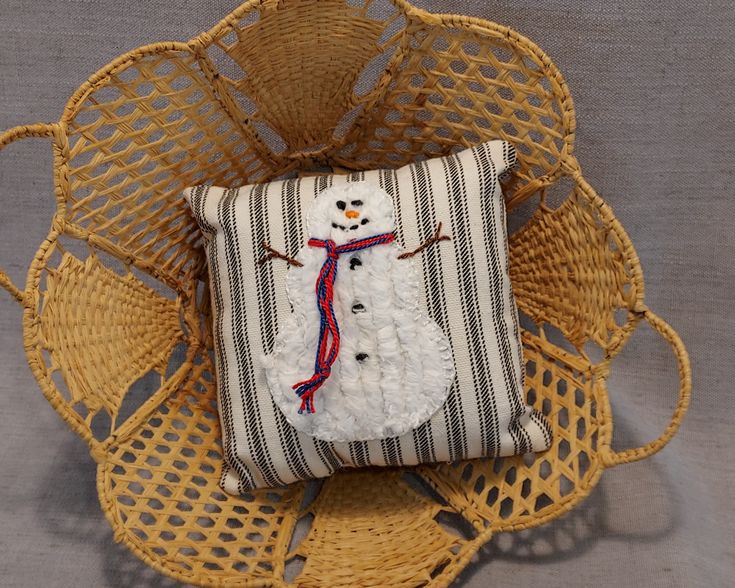 a snowman pillow sitting on top of a wicker chair