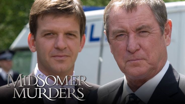 two men standing next to each other in front of a white truck with the words midsome murders written on it