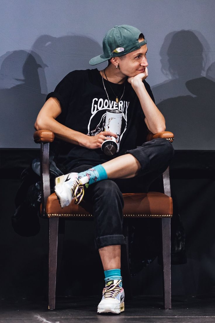 a man sitting on top of a wooden chair