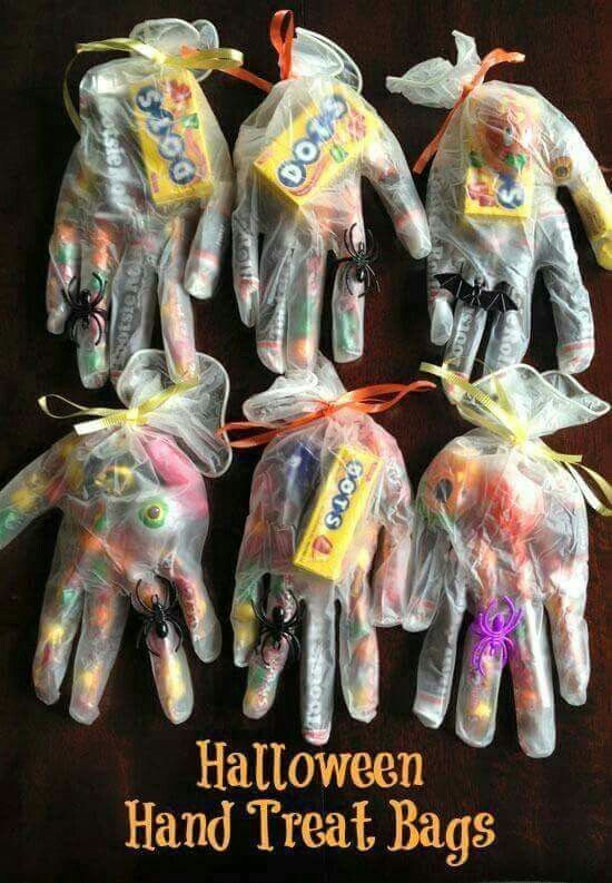 five halloween hand treat bags in the shape of hands with candy on them, all wrapped in plastic