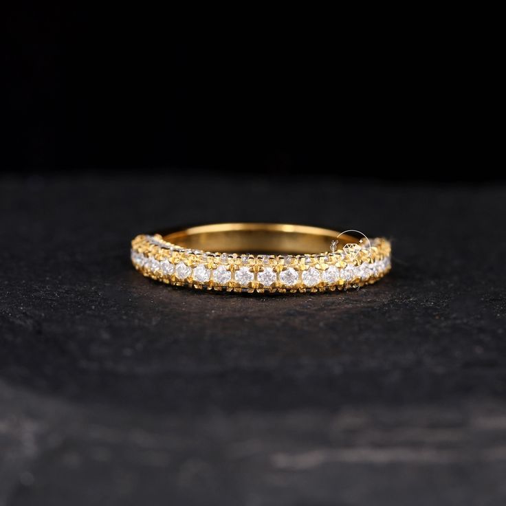 a yellow and white diamond ring sitting on top of a black surface