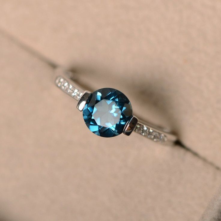 This ring features a 7mm round genuine London blue topaz and sterling silver finished with rhodium. Customization is available. It is made by hand, and it will take about 7 days to finish the ring after your payment is completed. Main stone: London blue topaz London blue topaz weight: Approx 1.60 ct Metal type: sterling silver finished with rhodium Accent stone: cz Customization is available, I also can make it with 14k solid gold (white or yellow or rose) and diamond accent stone, just feel fre Classic Round Topaz Birthstone Ring, Topaz Crystal Promise Ring, Classic Topaz Crystal Promise Ring, Classic Round Cut Topaz Birthstone Ring, Formal Topaz Crystal Ring, Elegant Topaz Crystal Ring Round Cut, Promise Topaz Ring, Sapphire-colored Topaz Ring With Round Cut, Blue Topaz Solitaire Ring Round Cut