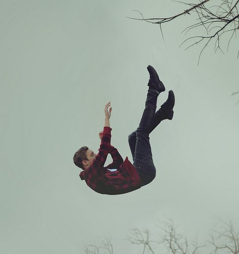 a man flying through the air while riding a skateboard in front of some trees