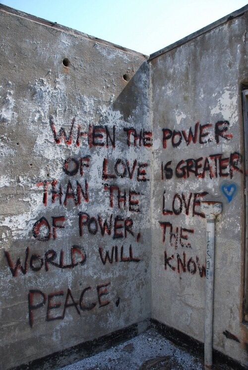 an open wall with graffiti on it that says, when the power of love is greater than the power of world will peace