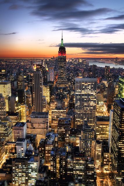 new york city skyline at night from the top of empire building, looking down on midtown