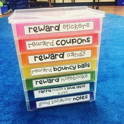 there is a stack of reward boxes on the blue carpet in front of some children's toys