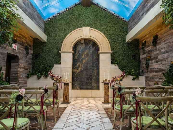 the inside of a church decorated with greenery and floral arrangements for an outdoor ceremony