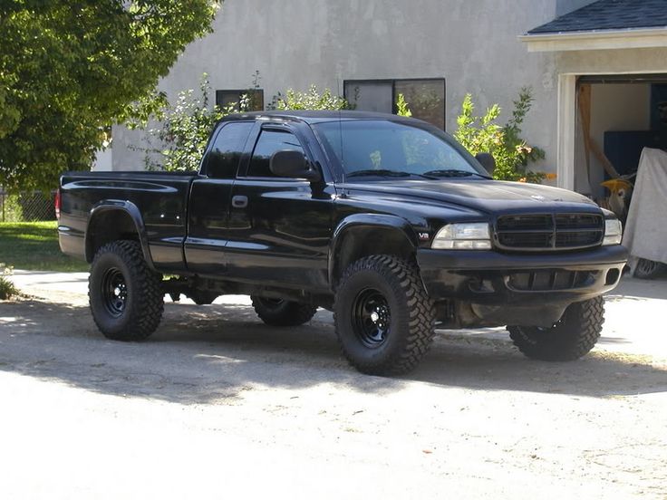 a black truck parked in front of a house