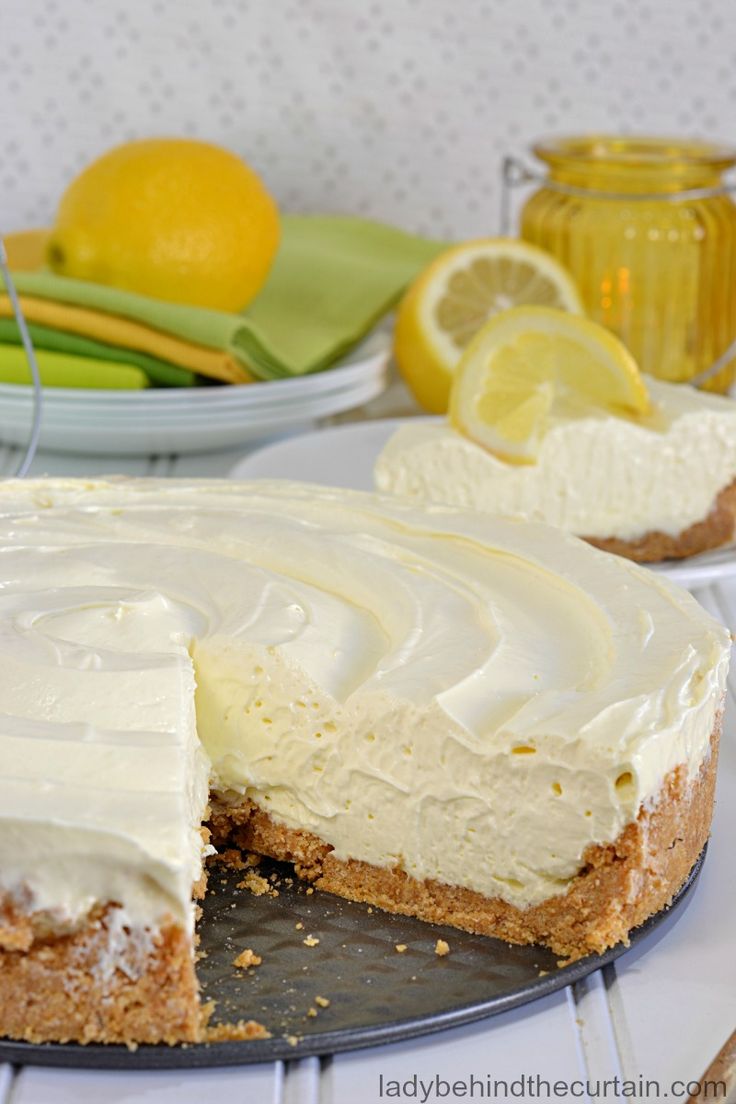 there is a cake with white frosting and lemons on the plate next to it