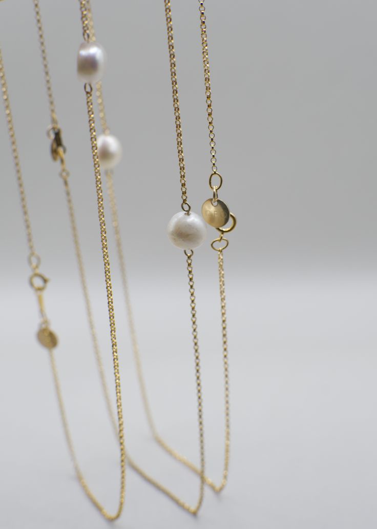 Named after a spin on the lovely Marigold flower, this pearl necklace symbolizes divinity as well as the beauty of patience on your journey to growth/alignment. She adds a simple-yet-striking touch of elegance and grace, and is very versatile for styling! Made with high-quality 14K Gold Filled materials, the Merrigold necklace is both water/tarnish-resistant, so you can swim all day and night under the sun and moon. NECKLACE DETAILS: 14K Gold-Filled Chain Freshwater Pearl Unique 14K Gold-Filled GEO Tag MEASUREMENTS: 16.5" Necklace Note: Many GEOLOVERS pieces are uniquely handmade. Each piece may vary slightly as a result, including the shapes of natural pearls. Spiritual Gold Pearl Necklace With Pearl Charm, Gold Pearl Necklace With Spiritual Charm, Spiritual Gold Pearl Necklace With Charm, Yellow Gold Long Necklace With Pearl Chain, Gold Spiritual Necklace With Pearl Drop, Spiritual Gold Necklaces With Pearl Drop, Spiritual Gold Necklace With Pearl Drop, Elegant Gold Long Necklace With Pearl Chain, Elegant Gold Long Charm Necklace