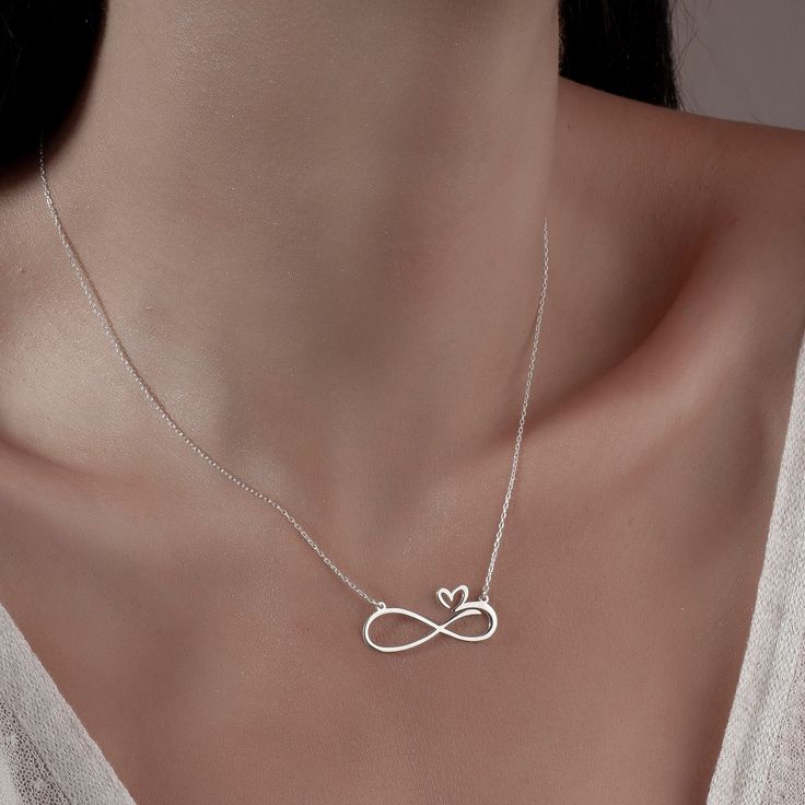 "Infinity Necklace with Hearts Necklace is made by hand in our workshop with care. All our jewelry is the most elegant choice for the Bridesmaids, friends, your loved ones and for yourself. Infinity Necklace with Hearts Necklace * Material: High Quality Solid 925 Sterling Silver. * Dimensions: Depending on your font choice, height sizes range from 1,5 mm to 3,5 mm lowercase. * Finish: Sterling Silver ∙ Gold ∙ Rose Gold. HOW TO ORDER ❓ * Select your necklace COLOR. * Choose necklace length from 14\" to 22\". The length option is the TOTAL chain length (including the charm). If you order an 18\" chain, the piece will come as CHAIN + CHARM = 18\".  * Finish your payment and complete your order. PRODUCTION TIME 🕒 All items made to order. Production starts within 12 hours and ships within 24 h Infinity Heart Necklace In Sterling Silver For Gift, Sterling Silver Infinity Heart Necklace As Gift, Heart And Infinity, Minimalist Necklace Silver, Fancy Jewelry Necklace, Handmade Gold Jewellery, Infinity Jewelry, Infinity Pendant, Infinity Heart