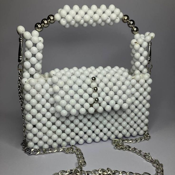 The Pure White Bag is a minimalist masterpiece, crafted entirely from glossy white beads. This 100% handmade accessory offers a clean and elegant design, lined with unique fabric for a touch of luxury. Perfect for adding a subtle yet sophisticated accent to any outfit. White Luxury Rectangular Evening Bag, Luxury White Rectangular Evening Bag, Formal White Bags With Pearl Handle, Chic White Bags With Pearl Handle, Luxury White Bags With Pearl Handle, White Square Evening Bag, Trendy White Evening Bag For Formal Events, Elegant White Handmade Shoulder Bag, White Rectangular Bag With Pearl Handle