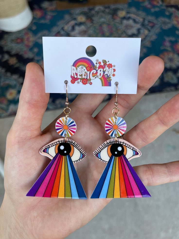 Step back in time to the psychedelic era with these 70s Retro Rainbow Eye Groovy Earrings. Inspired by the vibrant colors and mesmerizing patterns of the 1970s, these earrings feature a unique design that incorporates a rainbow eye motif. Crafted from lightweight acrylic, these earrings offer comfort without compromising on style. The hooks are made of stainless steel, coated in 18k gold for a touch of luxury, and are nickel-free to ensure a comfortable wearing experience. Product Details: Size: Retro Dangle Earrings For Festivals, Retro Multicolor Drop Earrings, Retro Rainbow Earrings For Gift, Retro Rainbow Jewelry For Gifts, Retro Multicolor Jewelry For Festivals, Multicolor Retro Festival Jewelry, Rainbow Retro Jewelry For Gift, Retro Rainbow Colored Jewelry Gift, Retro Rainbow Jewelry Gift