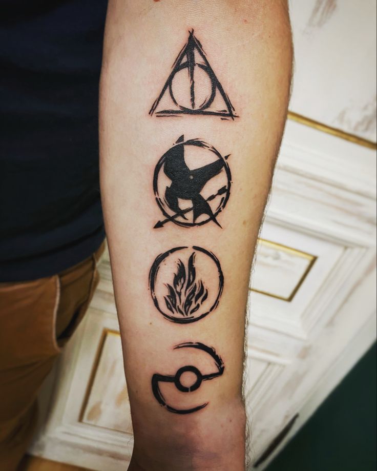 a person with a harry potter tattoo on their arm and the symbols for each element