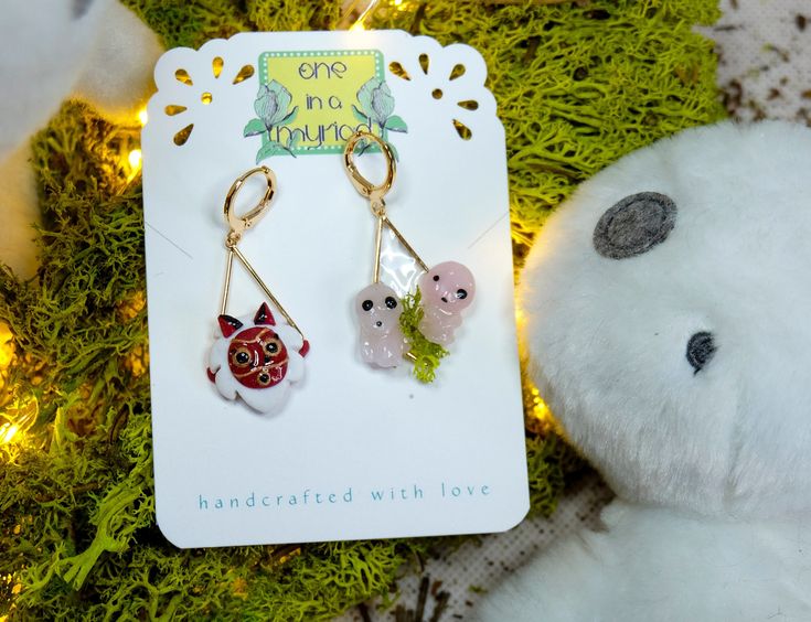 Mismatch dangling earrings, hand-sculpted lovingly out of polymer clay, and with a glaze of resin for a little bit of extra shine and sparkle, one featuring a Princess Mononoke mask and the other featuring two Kodama sitting on moss. These earrings are very light to wear and comfortable on the ears, thanks to the hypo-allergenic, nickel-free, gold-plated brass earring clasps. The metal frames upon which the Princess Mononoke and Kodama sit, are also gold-plated brass.  For the earrings to stay g Princess Mononoke San, Forest Spirits Princess Mononoke, Princess Mononoke Earrings, Princess Mononoke You're Beautiful, Forest Spirit Princess Mononoke, Stay Gold, Princess Mononoke, Perfume Spray, Brass Earrings