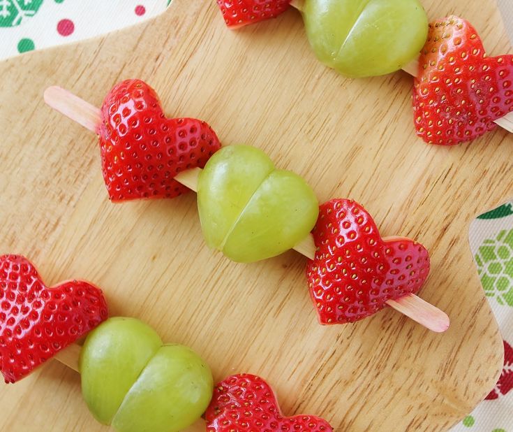 apples and strawberries are arranged on skewers to be used as fruit kabobs