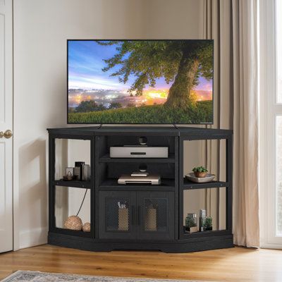 a flat screen tv sitting on top of a wooden stand in front of a window