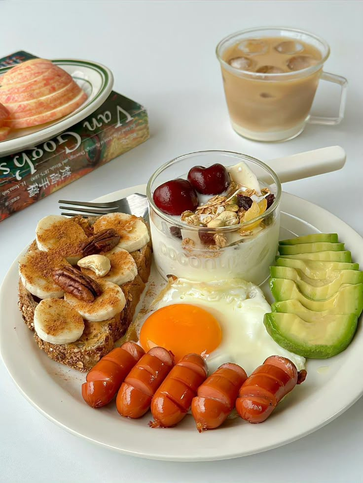 a white plate topped with eggs, sausages and fruit