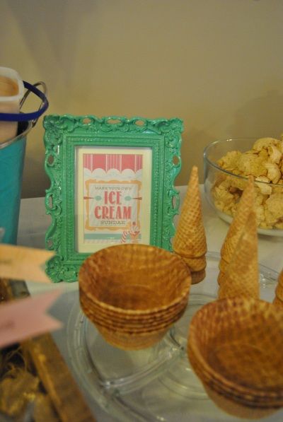 a table topped with baskets filled with food next to a framed sign and other items