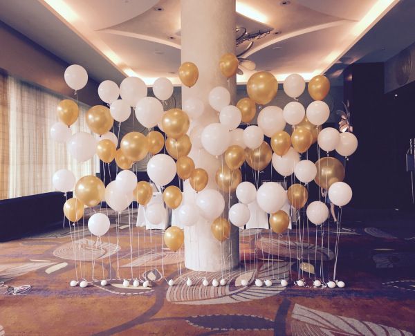 there are many white and gold balloons in the room