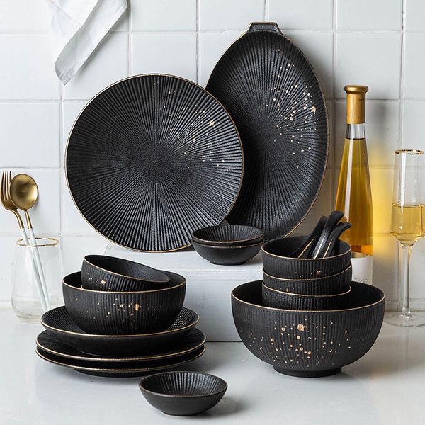 black dinnerware set with gold speckles on it