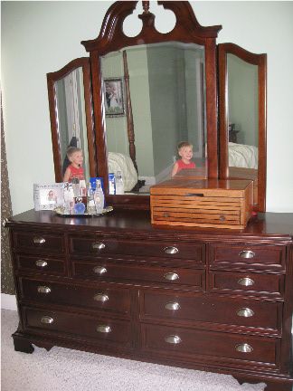 a dresser with a mirror and two children in it