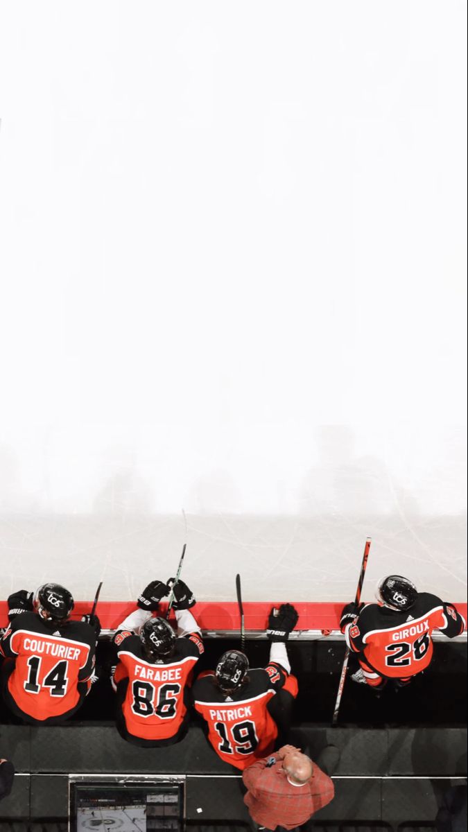 the hockey team's jerseys are hanging on the wall in front of the scoreboard