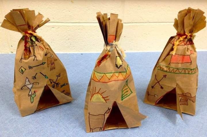 three brown bags with designs on them sitting on a blue surface