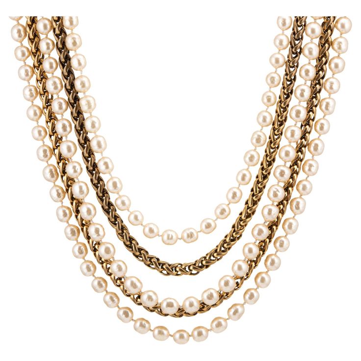 Vintage Chanel multi-strand necklace crafted in yellow gold tone (circa 1984). The necklace features 3 strands of 10mm faux pearls with 2 strands of yellow gold plated wheat-style chains. Measuring 17 inches in length the necklace is slightly adjustable to 19 inches. Given the multiple strands (and the thickness of the chain metal and faux pearl strands), the necklace sits shorter on the neck as a choker style. The faux pearls are in very good condition (no chips or flaking). The necklace is in very good condition showing minimal wear. Particulars: Weight: 100+ grams Size & Measurements: Measuring 17 inches in length the necklace is slightly adjustable to 19 inches. Given the multiple strands (and the thickness of the chain metal and faux pearl strands), the necklace sits shorter on the ne Necklace Craft, Chanel Vintage, Choker Style, Pearl Strands, Multi Strand Necklace, Vintage Chanel, Strand Necklace, Multi Strand, Faux Pearl