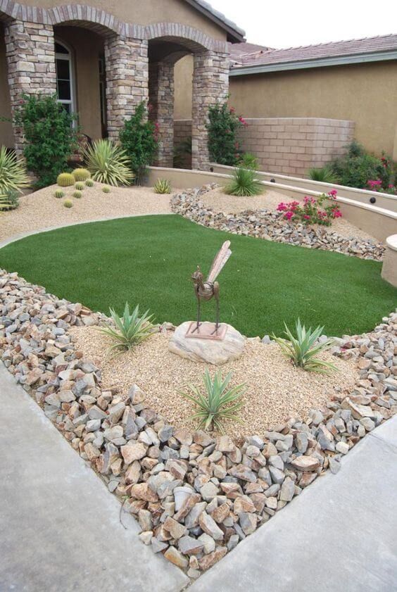 a yard with grass and rocks in the middle