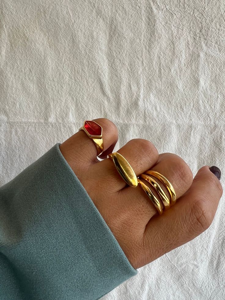 Three  different handmade rings for women with gold bands and unique designs that create a really unique set. The first one is a gold ring with a red stone from peweter on it. The middle one is a gold oval ring and the last one is a gold triple ring that catches the eyes. All these rings are slightly adjustable. You can wear them all together or separetely as well. Find them only at Christina Christi Store. 👉 My Rings Collection: https://etsy.me/2z6Fby0 👉 Express Shipping: https://etsy.me/3ikU Gold Rings Women, Gold Oval Ring, Triple Band Ring, Handmade Gold Ring, Triple Ring, Rings Women, Rings Collection, Gold Statement Ring, Oval Ring