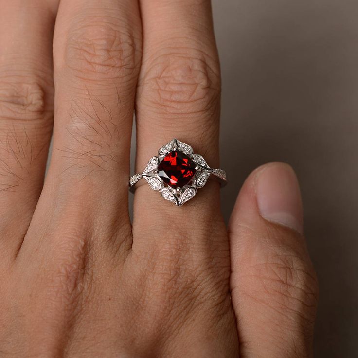 This is a gorgeous handmade creation. Its beauty is its simplicity & Elegance. The 7*7 mm cushion shape faceted natural garnet is crafted in solid sterling silver and with rhodium plated. All item is sent in a beautiful gift box If you have any idea of design your ring,pls contact me directly. You can realize more lovely stuff clicking the link https://www.etsy.com/shop/knightjewelry?refshopsection_shophome_leftnav Please leave the correct address and you phone number for delivering successf Garnet Wedding Rings, Red Gems, January Birthstone Rings, Garnet Engagement Ring, Red Garnet Ring, Ring Cushion, Cushion Cut Ring, January Birthstone, Garnet Ring