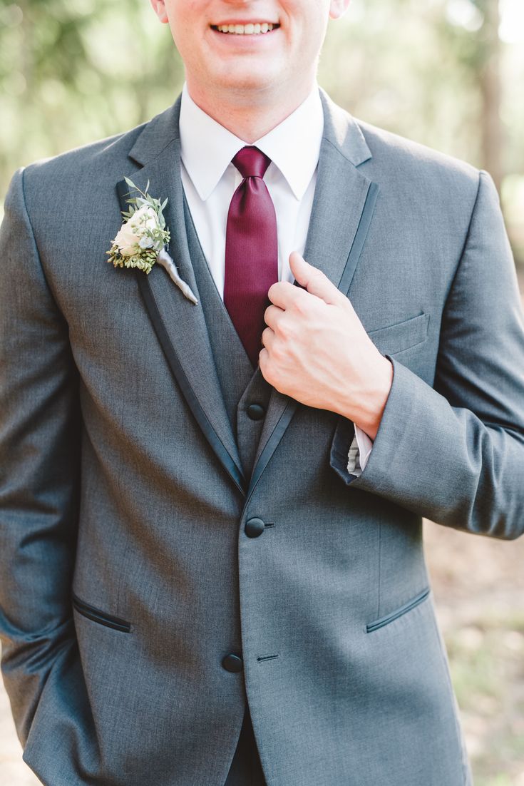 a man wearing a suit and tie with a boutonniere on his lapel