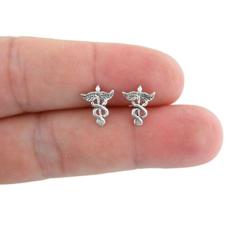 A tiny pair of sterling silver Caduceus earrings. Earrings are made of 925 silver and measure 10mm x 6mm. Mix and match with my other stud earrings Includes sterling silver ear backing This listing is for one pair (2 pieces). Symbolic Nickel-free Plug Earrings As Gift, Symbolic Nickel-free Plug Earrings For Gifts, Silver Symbolic Hypoallergenic Earrings, Silver Drop Cartilage Earrings As Gift, Silver Hypoallergenic Symbolic Earrings, Gift Dangle Earrings, Nickel-free Surgical Steel Plug Earrings For Gift, Sterling Silver Dangle Cartilage Earrings Gift, Silver Metal Cartilage Earrings As A Gift