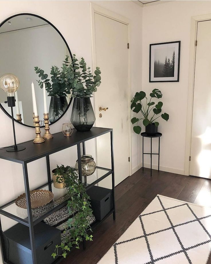 a room with a mirror, plant and other items on the shelf in front of it