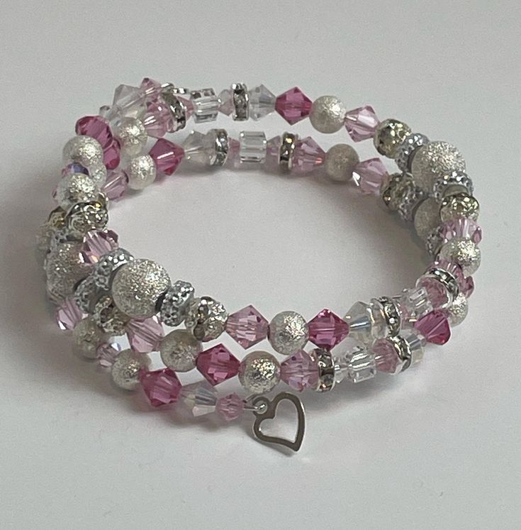 "Tickled Pink"- A smile that crosses your lips for no reason.  A private joke that pops into your head and sends a giggle through you that you cannot control.  That warm feeling of laughing with friends.  All those feelings of giddy joy are captured in this creation.  A beautiful memory wire bracelet with pink and clear Preciosa crystals. Our bracelets are creative, one of a kind pieces, each with their own unique names. No two bracelets are the same. This bracelet comes in an adorable cat shape Pink Hand Wrapped Wrap Bracelet With Round Beads, Pink Wire Wrapped Beaded Bracelets For Gifts, Pink Wire Wrapped Beaded Bracelets As Gift, Unique Adjustable Pink Beaded Bracelets, Pink Wrap Bracelet With Round Beads For Gifts, Adjustable Pink Hand Wrapped Crystal Bracelet, Adjustable Pink Crystal Hand Wrapped Bracelet, Beaded Pink Wrap Bracelet Gift, Pink Beaded Wrap Bracelet As Gift